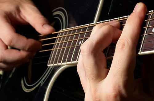 Guitarist Fretting a Barre Chord